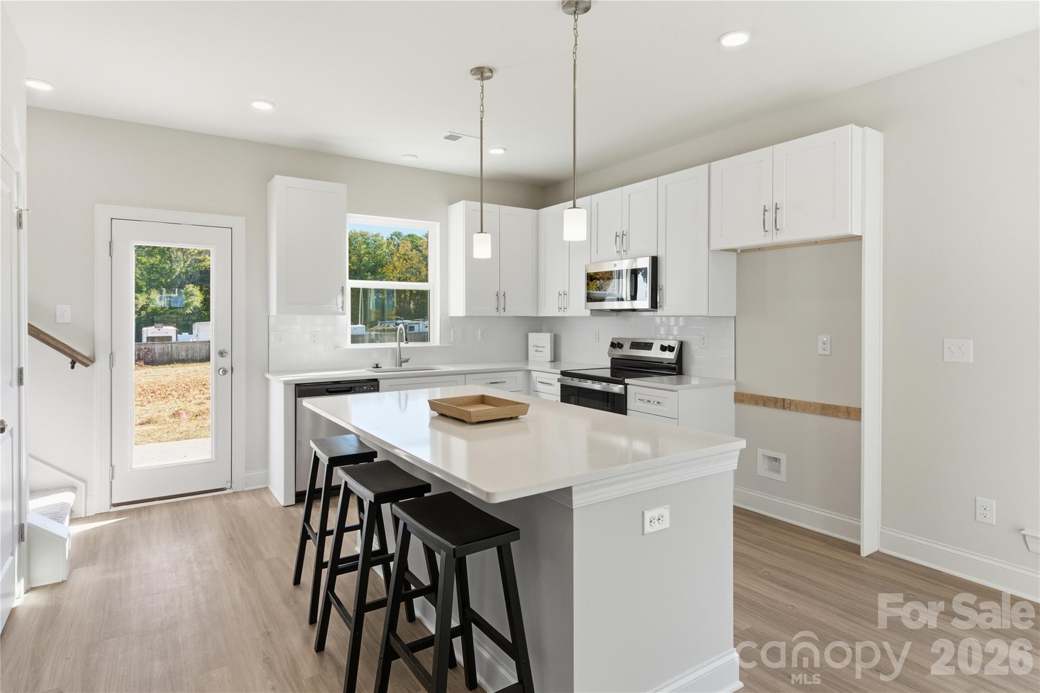 222 1st Street South Fort Mill, SC 29708 - Photo 5 of 23 a kitchen with stainless steel appliances a table chairs refrigerator and window
