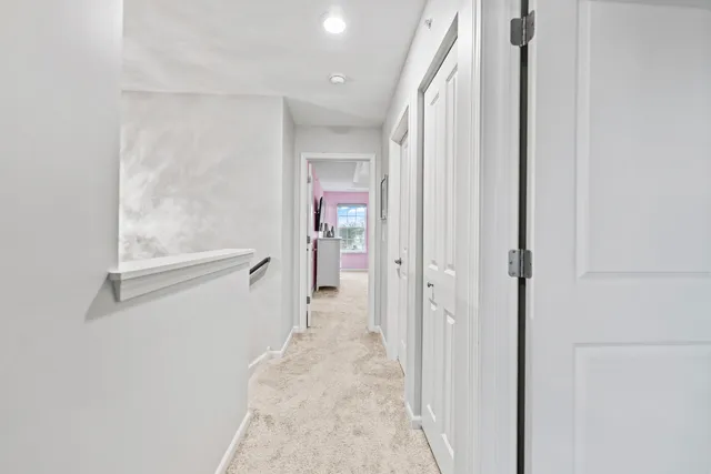 a spacious bedroom with a large bed a chandelier and windows