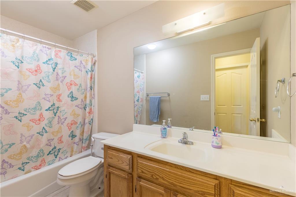 1801 Largo Street Weslaco, TX 78596 - Photo 11 of 20 a bathroom with a sink a toilet and shower curtain