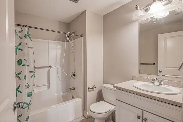 a bathroom with a granite countertop sink a toilet and shower