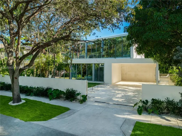 a view of a yard with plants and large trees