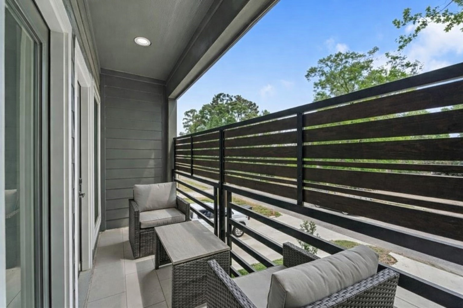 7709 Willow Street Houston, TX 77088 - Photo 7 of 15 This exterior view from the upper
balcony shows the gray
horizontal siding and black
horizontal railing, looking out
toward the street and
surrounding neighborhood.
**Virtually staged