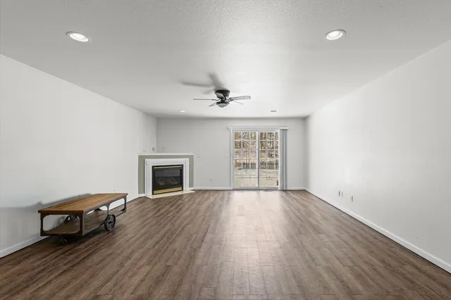 an empty room with windows and fireplace