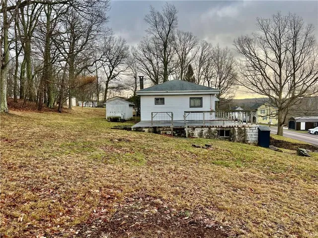 a front view of a house with a yard covered with snow
