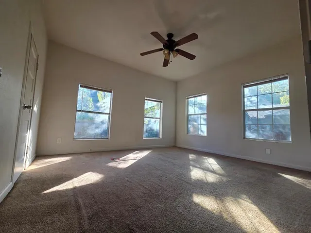 a view of a livingroom with a ceiling fan and window