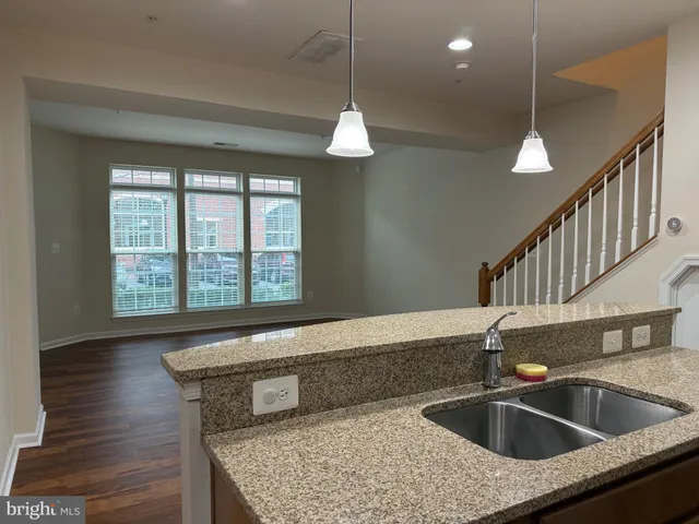 a kitchen with a sink a counter top with wooden floor