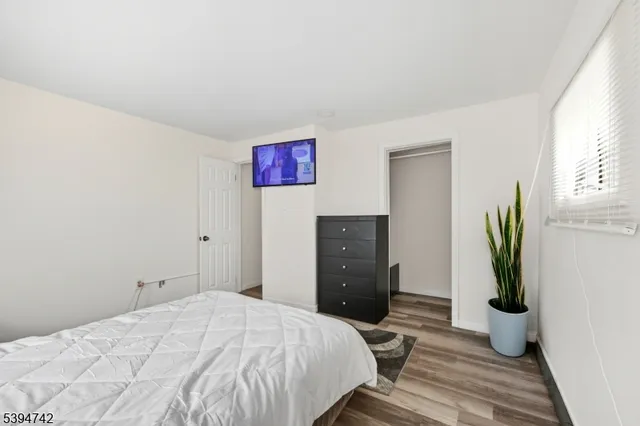 a bedroom with a bed and a potted plant