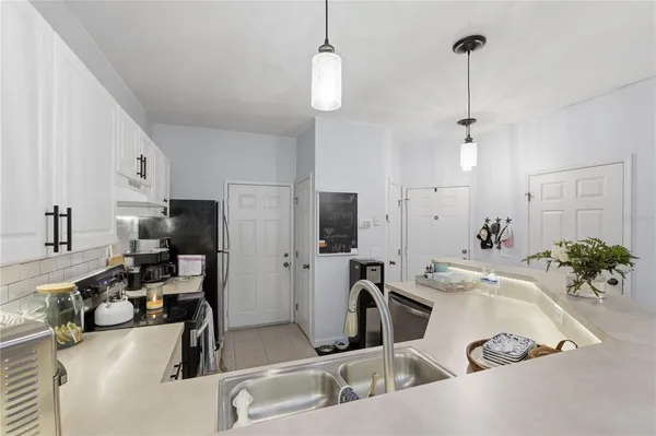 a living room with furniture and a dining table with kitchen view