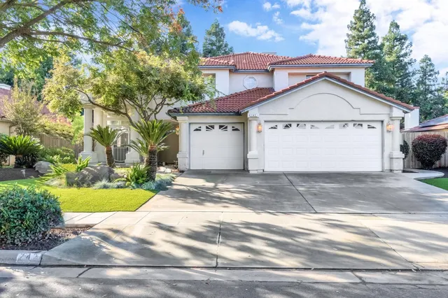 a view of a white house with a yard and plants