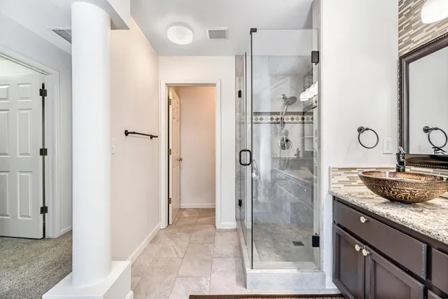 a bathroom with a double vanity sink mirror and shower