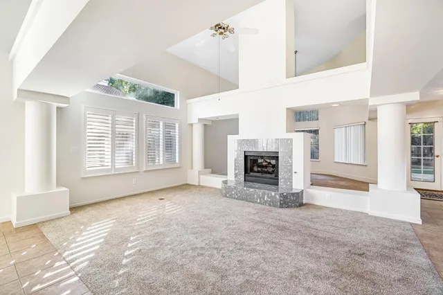 a view of an empty room with a fireplace and a window