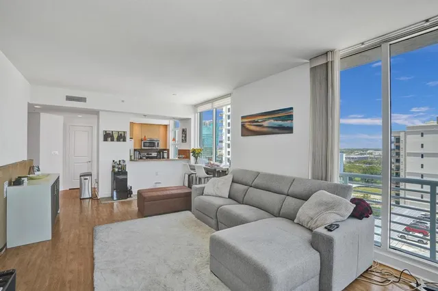 a living room with furniture and a view of kitchen