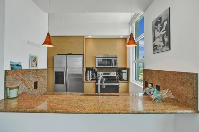 a kitchen with stainless steel appliances granite countertop a refrigerator oven a sink counter space and stainless steel appliances