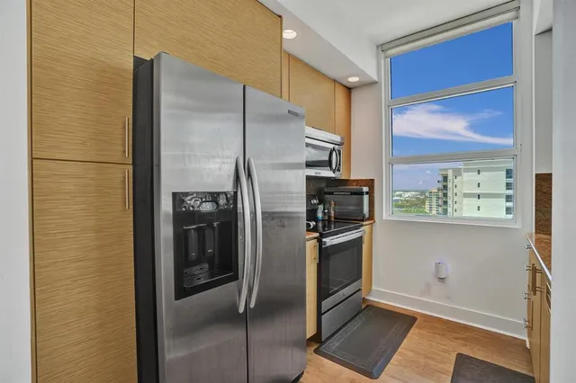 a kitchen with stainless steel appliances granite countertop a refrigerator and a stove