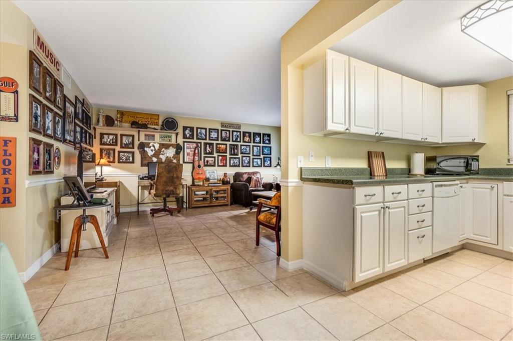4290 Gulfstream Drive, Unit 4 Naples, FL 34112 - Photo 14 of 20 a kitchen with cabinets and chairs