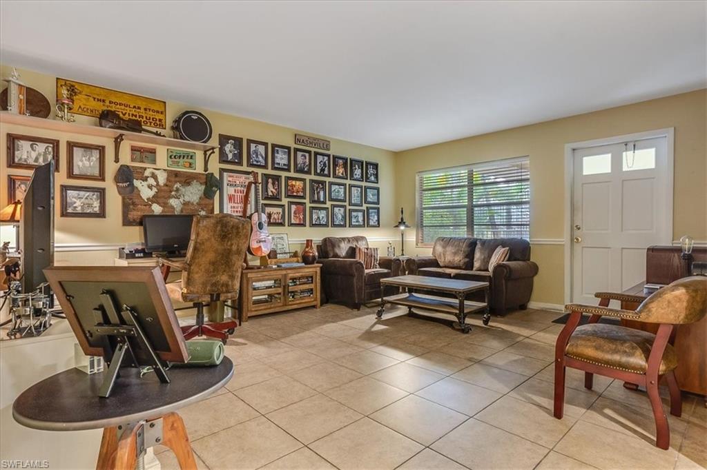 4290 Gulfstream Drive, Unit 4 Naples, FL 34112 - Photo 16 of 20 a living room with furniture a window and gym equipment