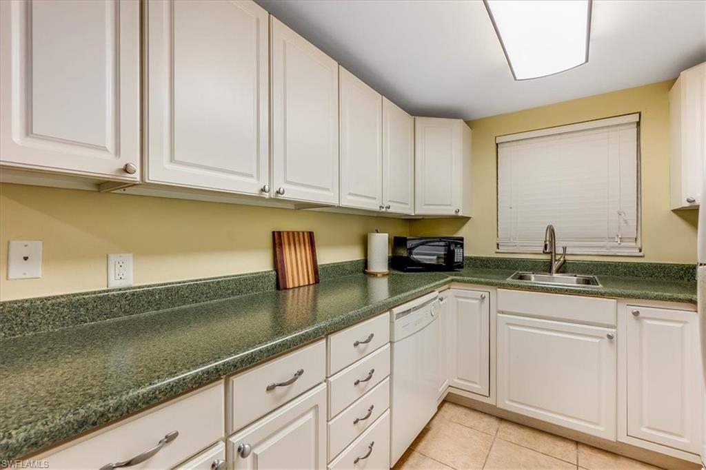 4290 Gulfstream Drive, Unit 4 Naples, FL 34112 - Photo 5 of 20 a kitchen with granite countertop white cabinets and a sink