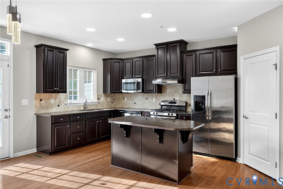 1903 Old Brick Road Glen Allen, VA 23060 - Photo 13 of 39 a kitchen with stainless steel appliances granite countertop a stove a sink dishwasher a refrigerator and a microwave oven with wooden floor