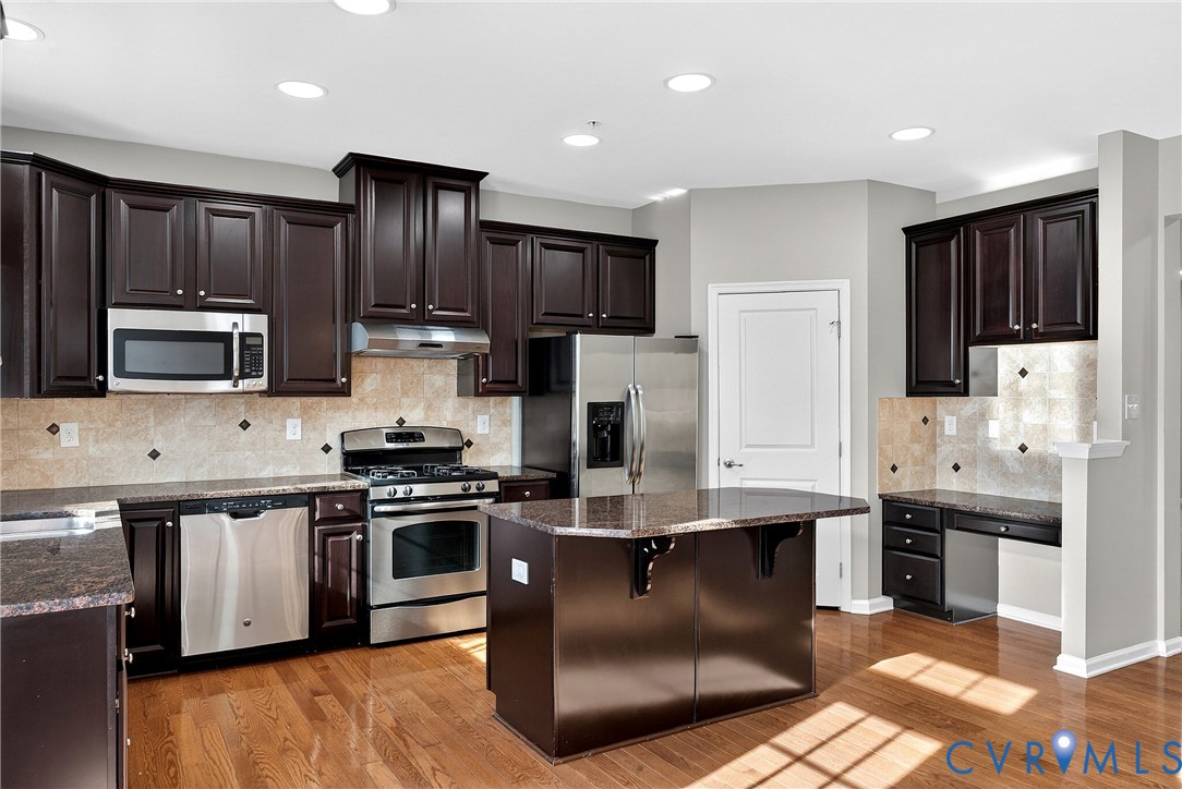 1903 Old Brick Road Glen Allen, VA 23060 - Photo 16 of 39 a kitchen with stainless steel appliances granite countertop a stove a sink dishwasher a refrigerator and a oven with wooden floor