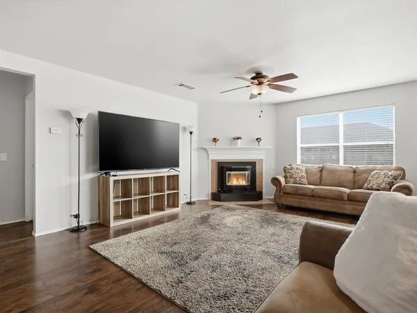 a living room with furniture a flat screen tv and a fireplace