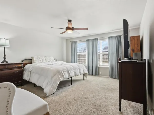 a spacious bedroom with a bed and wooden floor