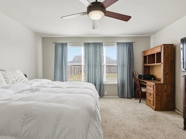 a bedroom with a bed flat screen tv and a window