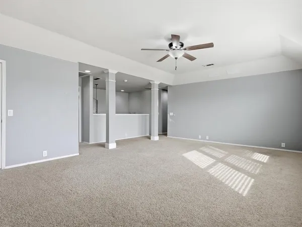 a view of an empty room with a ceiling fan