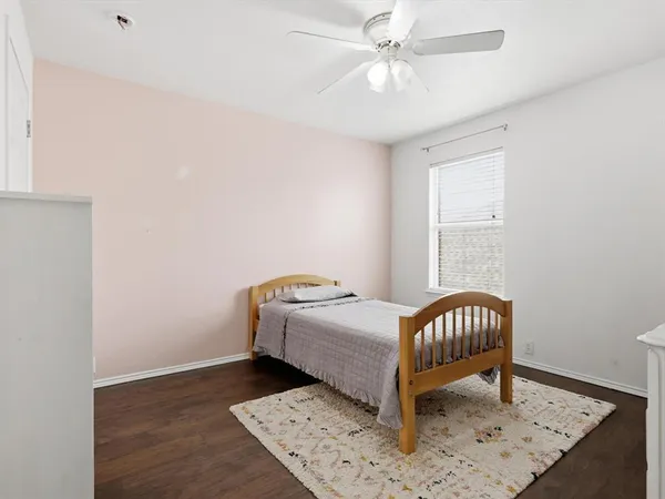 a room with a baby bed a chandelier and a dresser