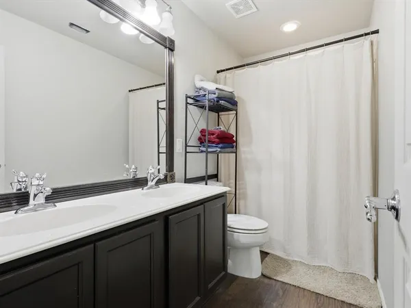 a bathroom with a sink vanity mirror and toilet