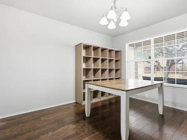 a workspace with wooden floor and a large window