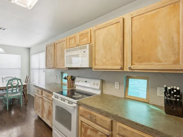a kitchen with stainless steel appliances granite countertop a stove a sink and white cabinets