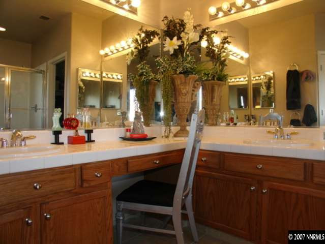 1445 Cayuse Way Reno, NV 89521 - Photo 7 of 9 a bathroom with a sink a large mirror and a light fixture