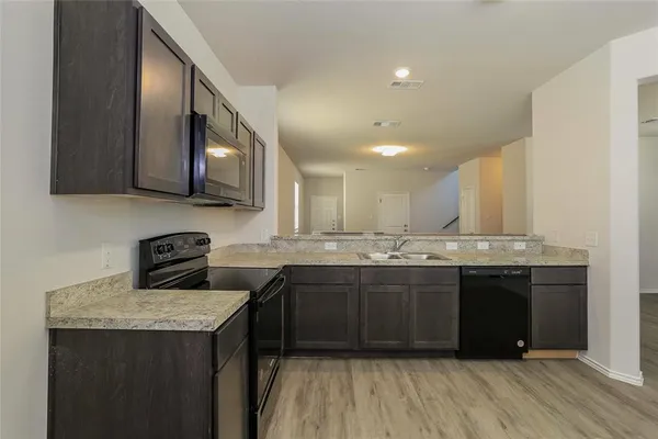 a kitchen with stainless steel appliances granite countertop a sink stove and cabinets