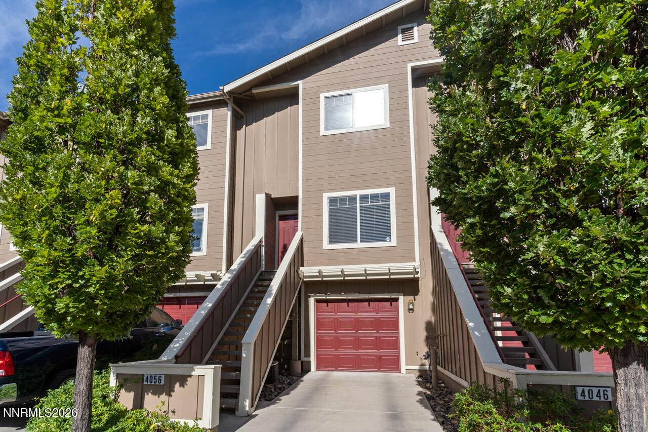 a front view of a house with a tree