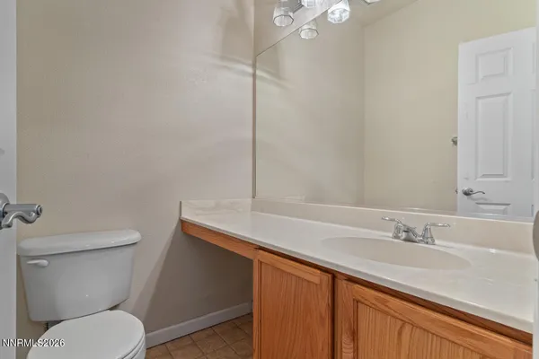 a bathroom with a granite countertop toilet sink and mirror