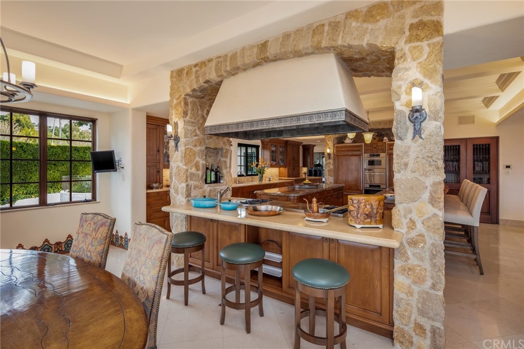 909 Vía Coronel Palos Verdes Estates, CA 90274 - Photo 59 of 59 a room with stainless steel appliances kitchen island granite countertop a table and chairs in it