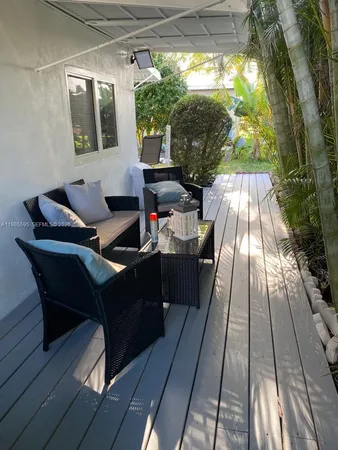 a view of a patio with table and chairs with wooden floor and fence