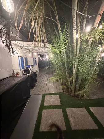 a view of backyard with a table and chairs under an umbrella