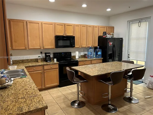 a kitchen with a sink refrigerator and cabinets