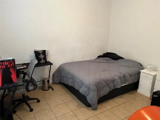 a bedroom with a bed and a chair in it