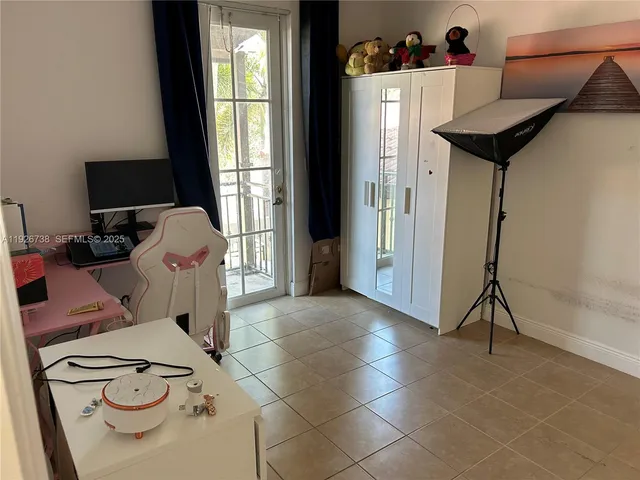 a view of a workspace with furniture and a window