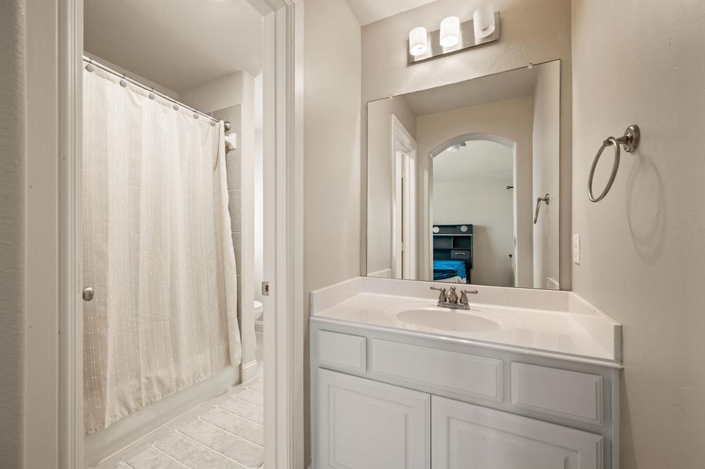 1521 Newton Ranch Road Keller, TX 76248 - Photo 30 of 40 Jack and Jill bathroom. White vanity with a single basin sink, brushed nickel faucet, and a large wall-mounted mirror