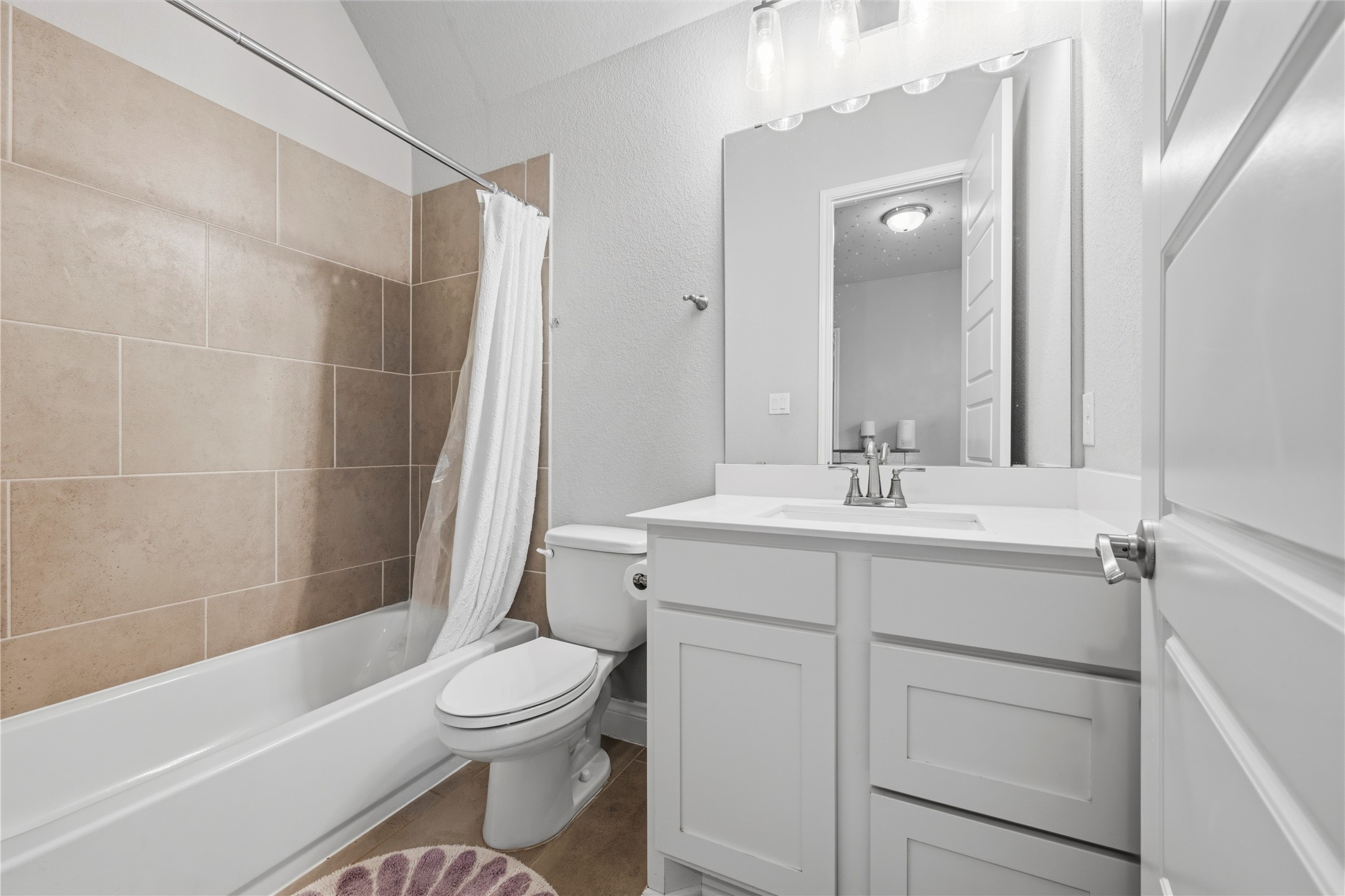 140 Catani Loop Georgetown, TX 78628 - Photo 26 of 36 A well-appointed bathroom with a white vanity and a tiled bath/shower combination.