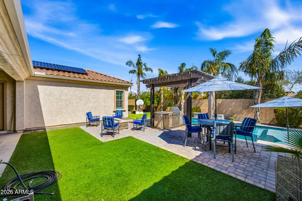 a view of a patio with table and chairs under an umbrella