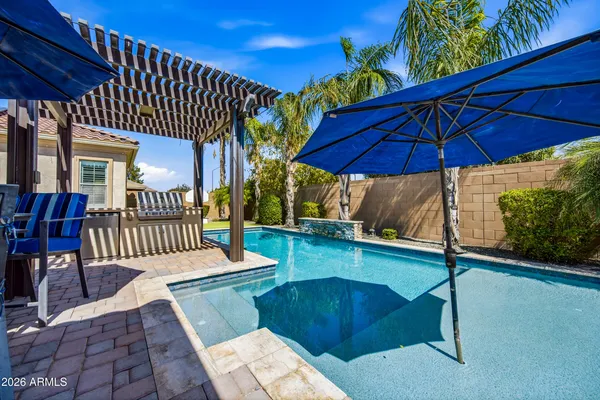 a view of a house with swimming pool and sitting area