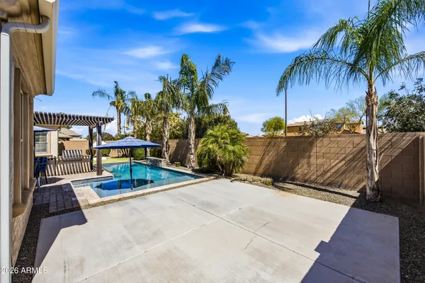a view of a patio with a table and chairs under an umbrella