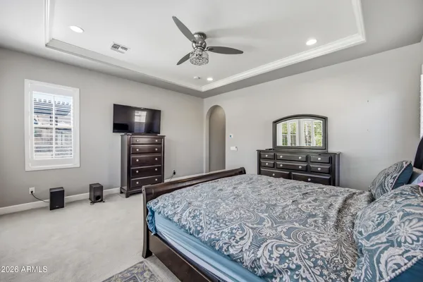 a bedroom with a bed a dresser and a flat screen tv