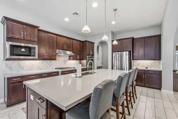 a kitchen with cabinets appliances and a dining table