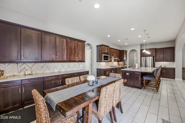 a kitchen with stainless steel appliances wooden cabinets a dining table and chairs