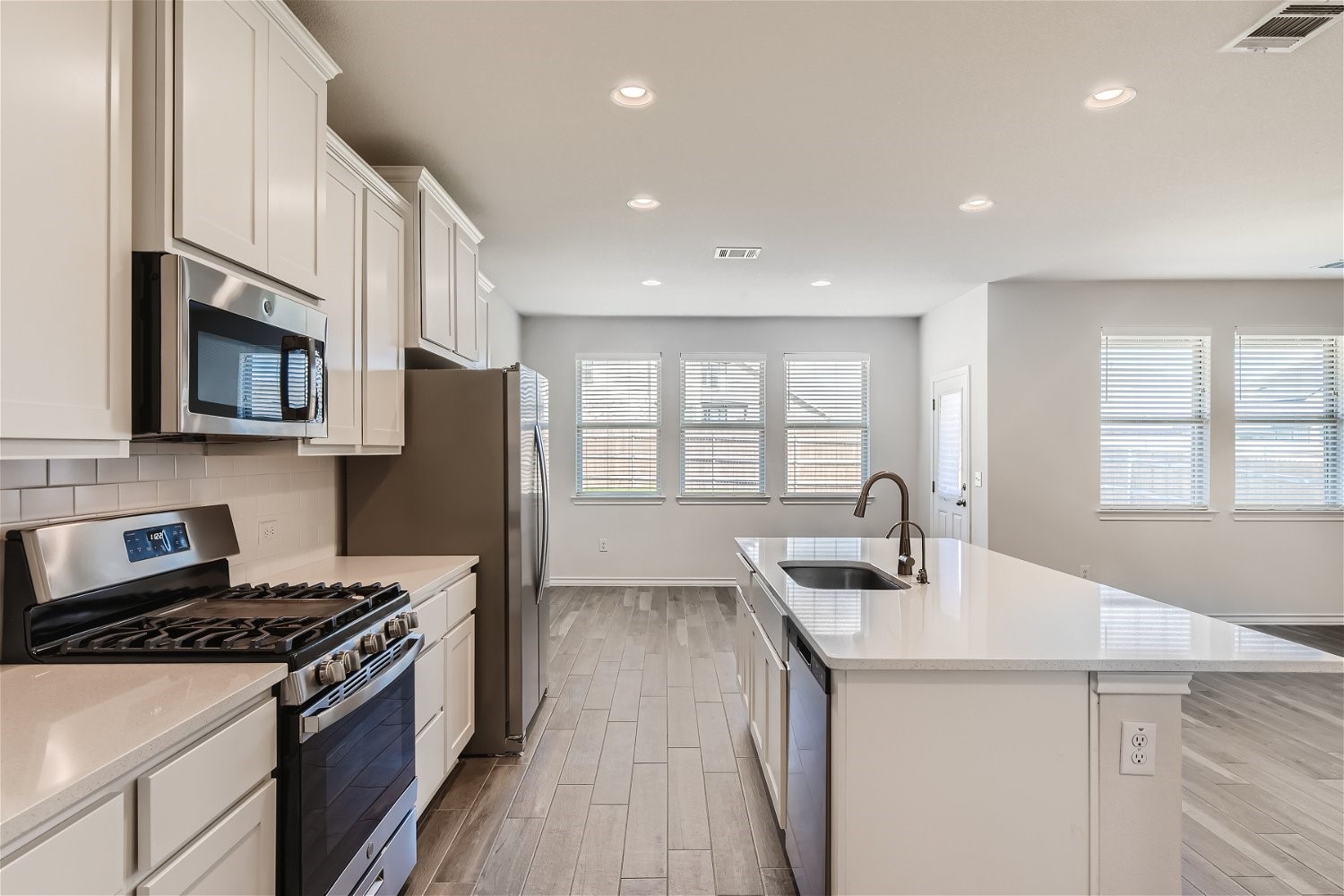 11612 Caithness Way Austin, TX 78754 - Photo 6 of 11 a kitchen with stainless steel appliances granite countertop a sink stove and refrigerator
